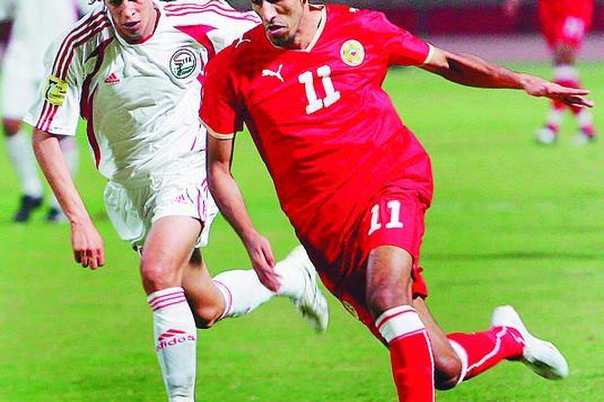 Pemain Bahrain, Ismail Abdulatif (kanan),menggiring bola melewati pemain Yaman, Khaled Hassan, dalam laga kualifikasi PialaAsia 2011 diManama, Bahrain, Rabu ( 18/ 11).