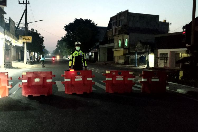 Petugas berjaga di titik penyekatan yang merupakan salah satu pintu masuk ke wilayah Kota Blitar, Sabtu (24/7/2021)