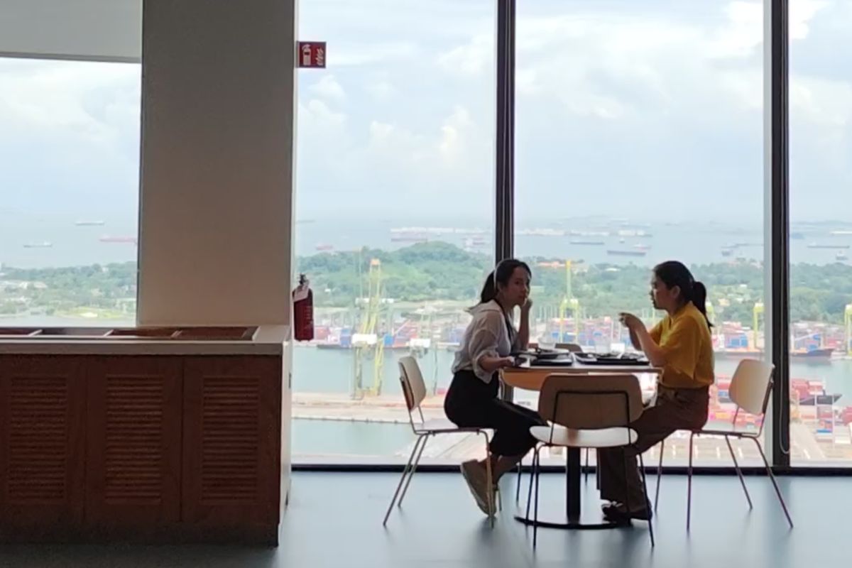 Suasana dua orang sedang makan di kantin kantor Meta di Singapura.