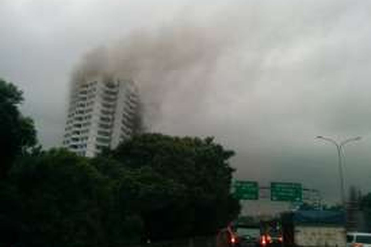 Asap hitam terlihat mengepul dari kebakaran yang terjadi apartemen Parama di Jalan TB Simatupang, Jakarta Selatan, Minggu (14/8/2016).