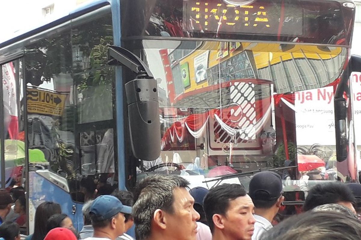 Bus Transjakarta melintas ditengah kerumunan pengunjung Karnaval Cap Go Meh Glodok, Jakarta Barat pada Minggu (4/3/2018).