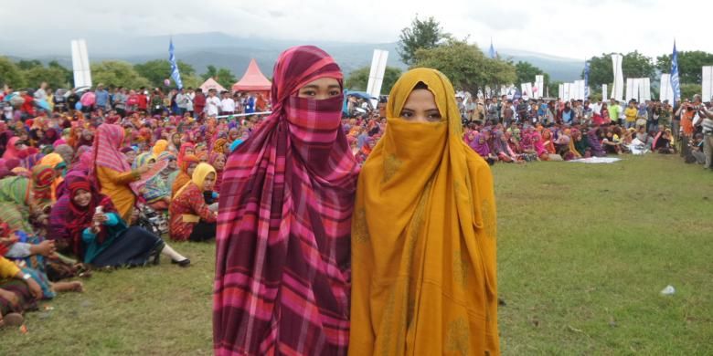 Dua perempuan suku Mbojo diabadikan saat menghadiri acara pembuka Festival Pesona Tambora di Doro Ncanga, Kabupaten Dompu, Nusa Tenggara Barat, Jumat (15/4/2016). Perempuan suku Mbojo yang belum menikah mengenakan rimpu atau balutan kain tanpa memperlihatkan wajah mereka seutuhnya, sedangkan yang telah menikah, rimpu dipasang tidak menutup wajah. 