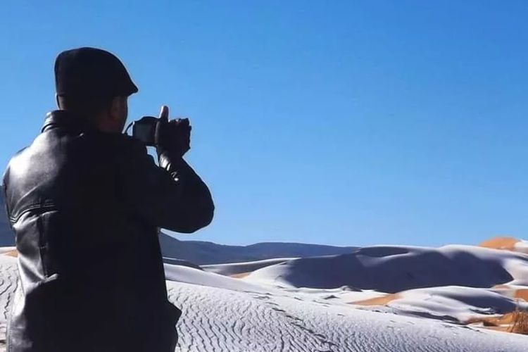Fotografer Karim Bouchetata sedang mengabadikan salju di Gurun Sahara. 
