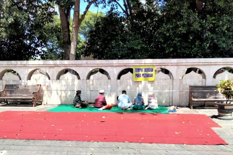 Peziarah rela berdoa di atas hamparan karpet di luar pagar Makam Bung Karno di Kelurahan Bendogerit, Kota Blitar, Kamis (9/9/2021)