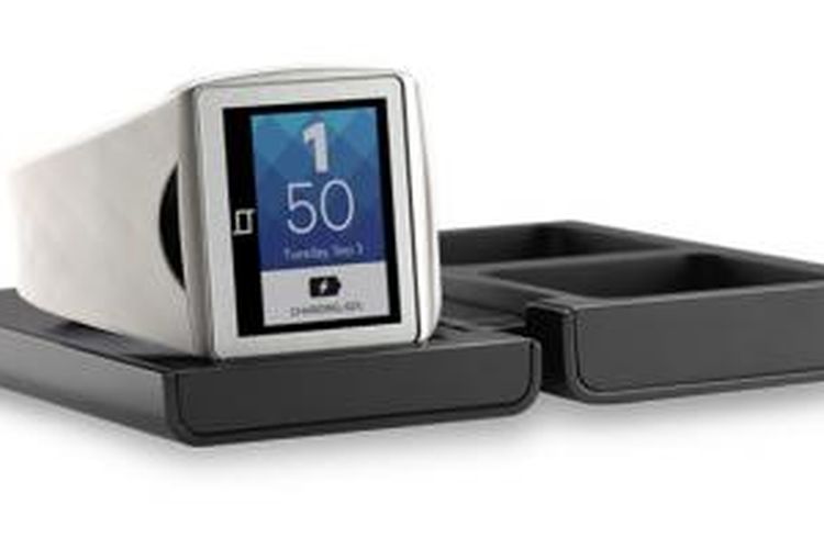 Jam tangan pintar Qualcomm Toq duduk di atas perangkat charger wireless pendampingnya