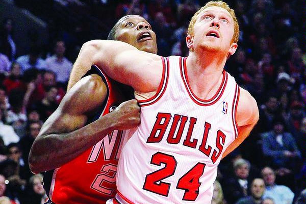 Forward Chicago Bulls, Brian Scalabrine (kanan), saling berkutat dengan forward  New Jersey Nets, Larry Owens, saat menunggu bola pantul dalam laga NBA di Chicago, Amerika Serikat, Senin (23/1).