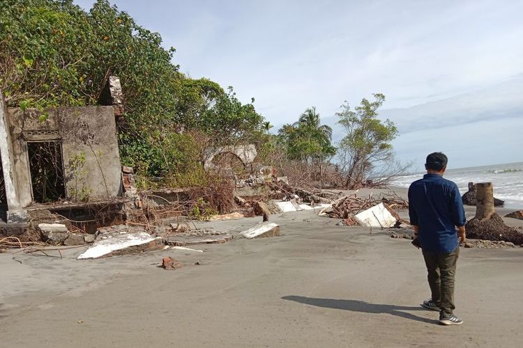 Sekretaris KAN Tiku Lima Jorong Agusmaidi sedang berada di puing rumah yang hancur akibat abrasi. 