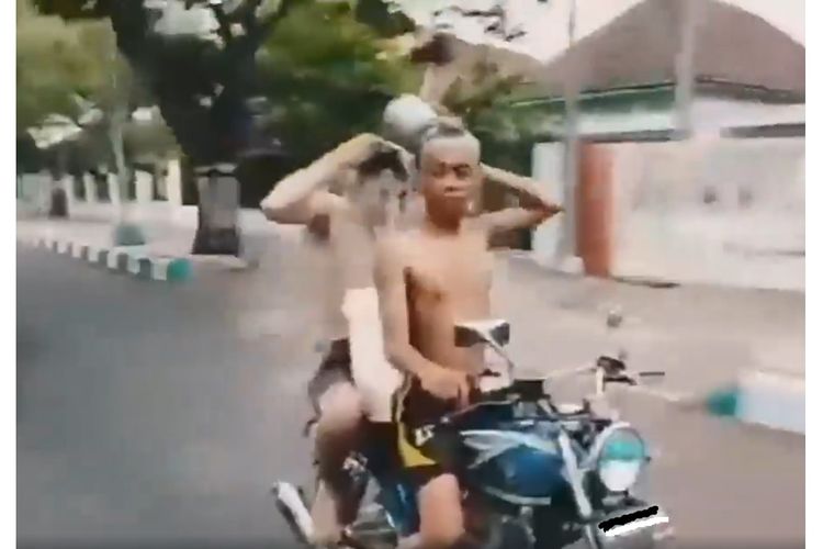 Tangkapan layar dari sebuah video yang memperlihatkan dua orang remaja tengah mandi disaat mengendarai sepeda motor di Pasuruan.