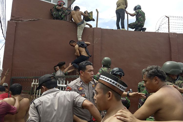 Petugas gabungan menggiring narapidana pascakerusuhan di Rumah Tahanan Negara (Rutan) Kelas II B Kabanjahe, Kabupaten Karo, Sumatera Utara, Rabu (12/2/2020). Menurut Kepala Bagian Humas Ditjen Pemasyarakatan Rika Aprianti, pemicu kerusuhan yang terjadi di rutan tersebut disebabkan adanya warga binaan pemasyarakatan yang tidak terima atas upaya pemberantasan narkoba di dalam rutan.