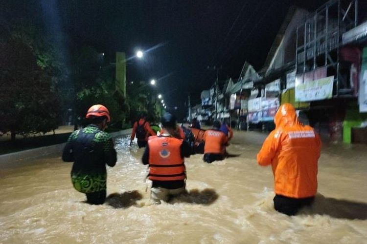 Petugas gabungan menyisir rumah-rumah untuk mencari warga yang kemungkinan terjebak banjir di dalam rumah, Minggu (28/11/2021). 