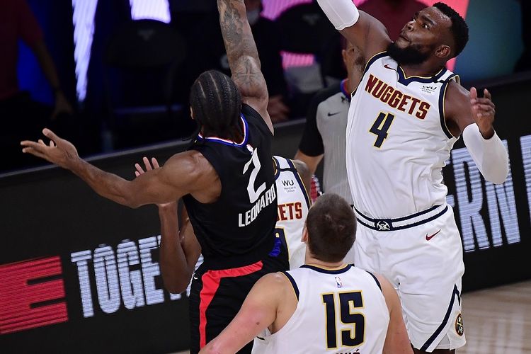 Kawhi Leonard (nomor 2) dari LA Clippers melaju ke ring dalam penjagaan Paul Millsap dan Nikola Jokic dari Denver Nuggets pada Playoff NBA 2020 di AdventHealth Arena di ESPN Wide World Of Sports Complex pada 15 September 2020. 