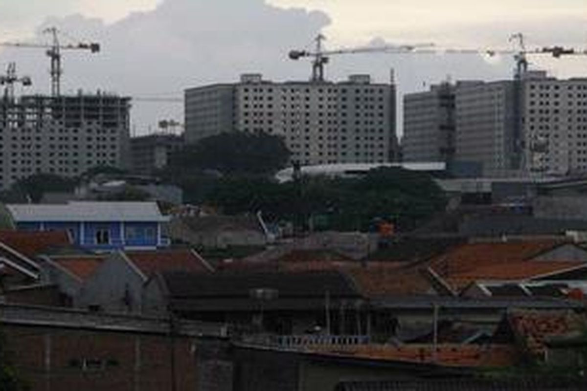 Pembangunan apartemen di tengah kawasan padat penduduk terus berlangsung di Kalibata, Jakarta Selatan, Rabu (17/3/2010). Keterbatasan stok lahan di perkotaan membuat harga lahan makin mahal. Hingga tahun 2009 kekurangan perumahan di Indonesia mencapai 8,6 juta unit. Adapun laju kebutuhan rumah baru setiap tahun 700.000 unit.