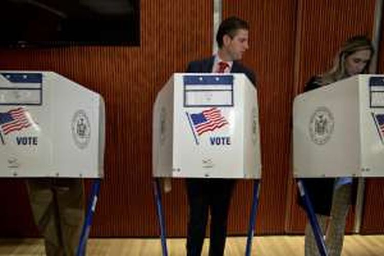 Eric Trump (tengah) melirik ke bilik pemungutan suara istrinya, Lara Yunaska, saat hadir di tempat pemungutan suara di New York, AS, (8/11/2016).