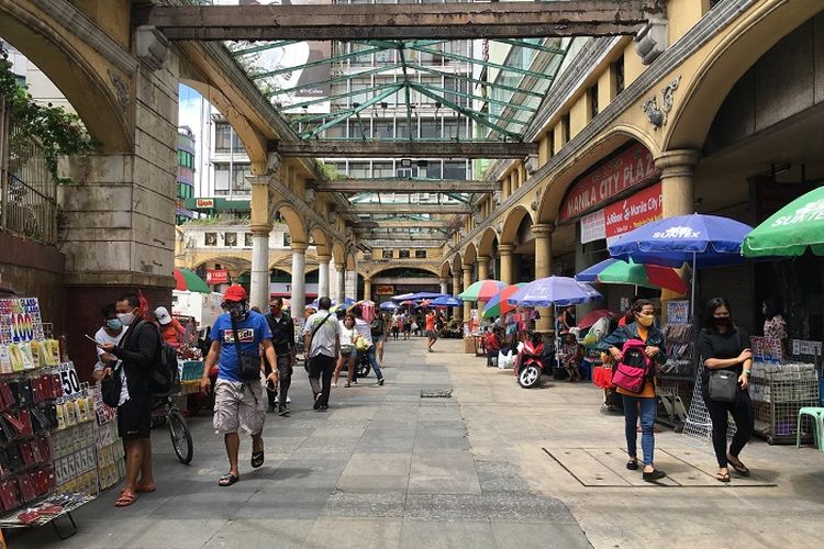 An image of people walking outside a commercial building in the Philippines. 