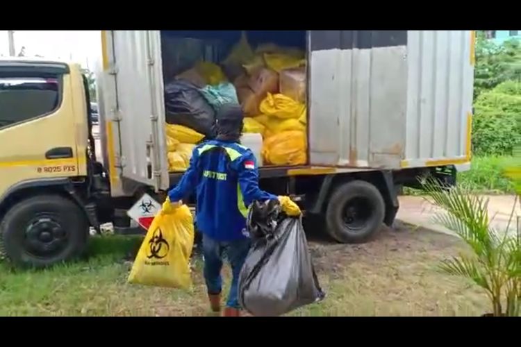 Petugas sedang memasukan sampah masker ke dalam truk di Gudang Dinas LH, Bambu Larangan, Cengkareng Barat, Jakarta Barat