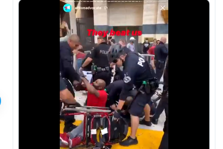 Tangkapan layar video seorang laki-laki terjatuh dari kursi rodanya saat unjuk rasa di Los Angeles