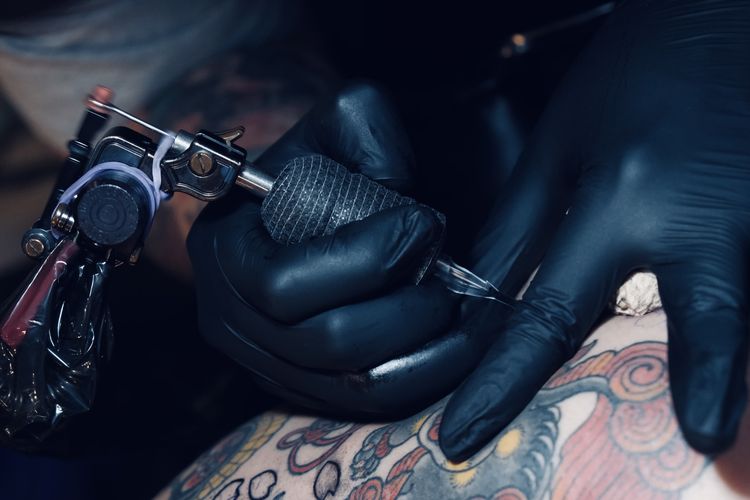 Arnaz Aditya Pratama tattoo artist sekaligus pemilik Sankara Tattoo Skinart studio saat menato kliennya di Pakuwon Trade Center (PTC) Surabaya.

