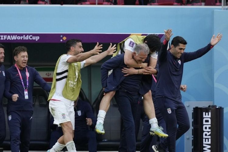 Pelatih timnas Iran, Carlos Queiroz, menggendong Sardar Azmoun, pada laga Grup B Piala Dunia 2022 kontra Wales di Ahmed bin Ali Stadium, Jumat (25/11/2022).