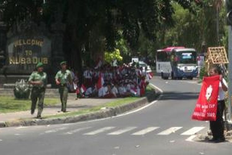 Aparat TNI akan mengamankan Sarman El-Hakim yang sedang membentangkan bendera di depan pintu masuk lokasi KTT APEC, Senin (07/10/2013).