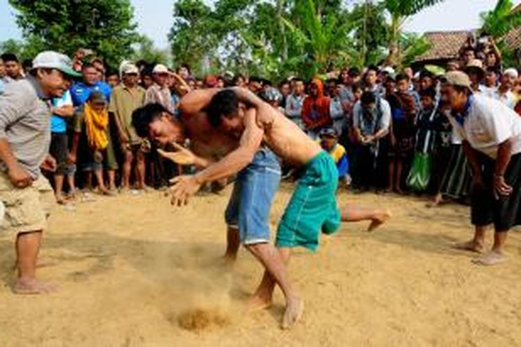 Warga dari berbagai kecamatan di Pamekasan, menggelar tradisi Okol sambil menunggu musim hujan tiba.