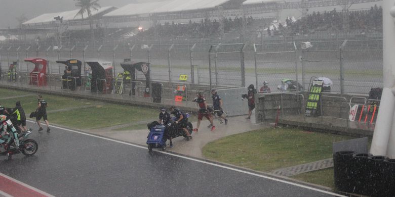 Suasana saat para pebalap dan kru tim tergesa-gesa kembali ke paddock di tengah hujan deras yang mengguyur kawasan Sirkuit Mandalika jelang Race 1 kelas World Superbike, Sabtu (20/11/2021).