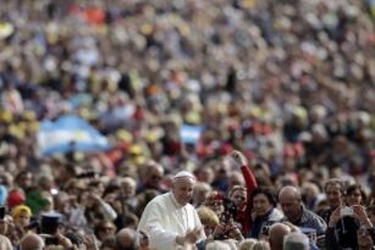 Paus Fransiskus memberkati umat saat pertemuan umum mingguan di Alun-alun St Peter di Vatican, 9 Oktober 2013.