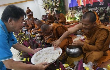 Umat Buddha (kiri) memberikan persembahan makanan kepada biksu yang mengikuti  perjalanan ritual keagamaan (thudong)  di Bekasi, Jawa Barat, Jumat (12/5/2023). Sebanyak 32 biksu dari sejumlah negara tersebut jalan kaki dari Thailand menuju Candi Borobudur  dalam rangka menyambut Hari Raya Waisak pada 4 Juni 2023.
