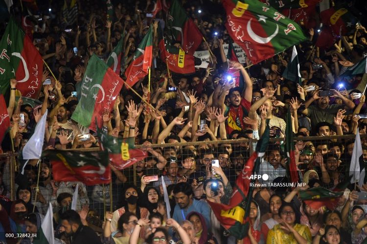 Pendukung partai Pakistan Tehreek-e-Insaf (PTI) dari Perdana Menteri Pakistan Imran Khan yang digulingkan, mengibarkan bendera partai sebagai aksi protes menentang penggulingannya di Karachi, Minggu (10/4/2022). 