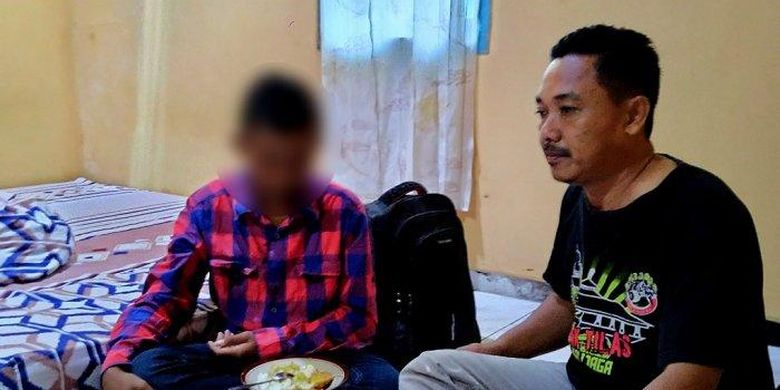 Bocah yatim piatu PR duduk di samping Nur Kholis, seorang ketua RT di jalan Blancir Raya, Jumat (21/2/2020). 