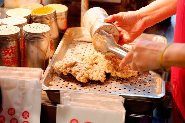 Pedagang tengah memberi bumbu ayam goreng khas Taiwan