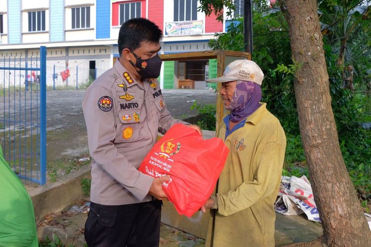 Kabid Humas Polda Riau Kombes Pol Sunarto menyerahkan bantuan paket sembako kepada seorang pemulung di Kota Pekanbaru, Riau, Jumat (27/8/2021).