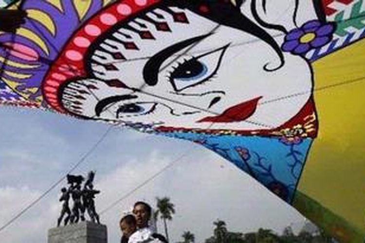 Peserta berusaha menaikkan layang-layang dalam Festival Layang-layang yang diselenggarakan Sudin Pariwisata, Jakarta Pusat di Taman Silang Monas, Jakarta Pusat, Minggu (11/7/2010). Festival Layang-layang digelar untuk memeriahkan HUT ke-483 Kota Jakarta dan mengusung tema Go Green Jakarta dengan mengajak masyarakat untuk mencintai permainan rakyat tersebut. KOMPAS/AGUS SUSANTO