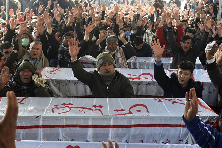 Para pelayat dari komunitas Syiah Hazara meneriakkan slogan-slogan di dekat peti mati para penambang yang tewas dalam serangan oleh orang-orang bersenjata di daerah pegunungan Machh, selama protes duduk di jalan bypass timur, di pinggiran Quetta pada 4 Januari 2021. Ribuan pelayat dari komunitas minoritas Syiah Pakistan pada 4 Januari memprotes bersama mayat penambang yang tewas dalam serangan yang diklaim oleh kelompok ISIS.