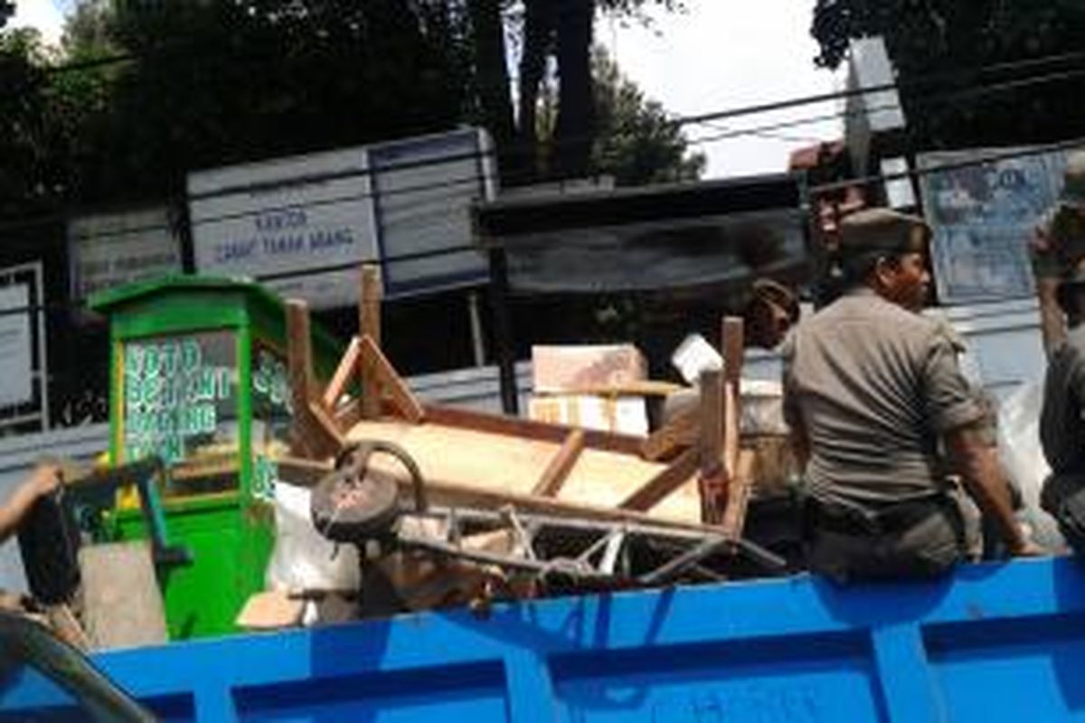 Petugas Satpol PP Jakarta Pusat menertibkan PKL yang kembali turun ke jalan di kawasan Pasar Tanah Abang, Senin (9/6/2014).
