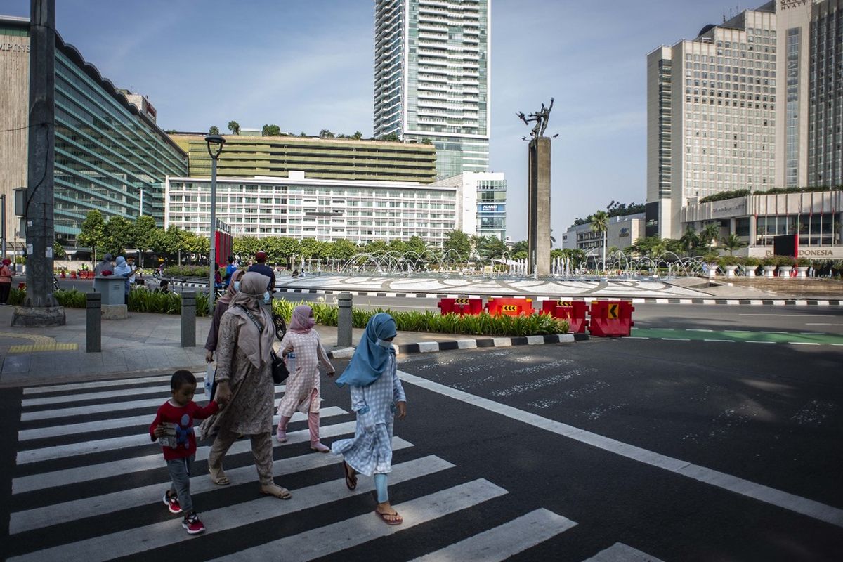 Sejumlah warga berjalan di kawasan Bundaran HI, Jakarta, Minggu (10/10/2021). Aktivitas warga di kawasan tersebut relatif ramai saat penerapan Pemberlakuan Pembatasan Kegiatan Masyarakat (PPKM) di ibu kota. ANTARA FOTO/Aprillio Akbar/aww.