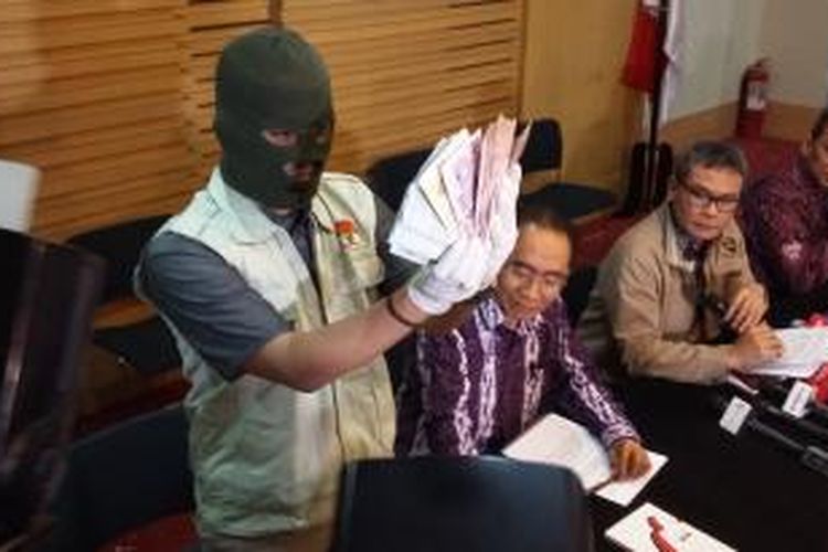 Penyidik KPK menunjukkan barang bukti uang sebesar 177.700 dolar Singapura, dalam konferensi pers di Gedung KPK, Jakarta, Rabu (21/10/2015).