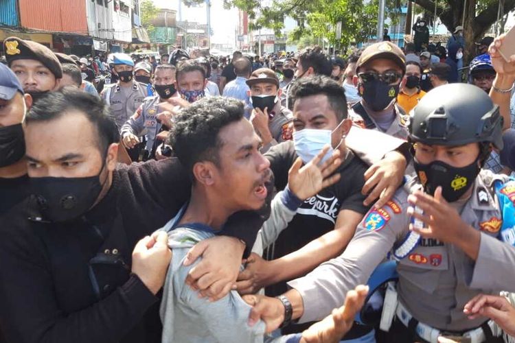 Aparat kepolisian menangkap sejumlah mahasiswa saat aksi unjuk rasa menolak penerapan pembatasan kegiatan masyarakat (PPKM) di depan kantor Wali Kota Ambon berujung bentrok, Jumat (16/7/2021)