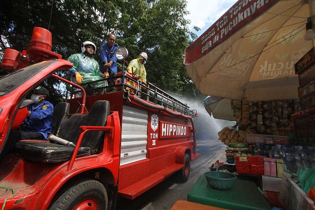 Petugas Damkar menyemprotkan cairan disinfektan di jalan Kapten Piere Tandean kawasan Siring Menara Pandang, Banjarmasin, Kalimantan Selatan, Senin (23/3/2020). Penyemprotan cairan disinfektan serentak di kota Banjarmasin tersebut sebagai salah satu upaya antisipasi penyebaran virus COVID-19 mengingat telah ditemukannya satu kasus positif di Kalimantan Selatan.