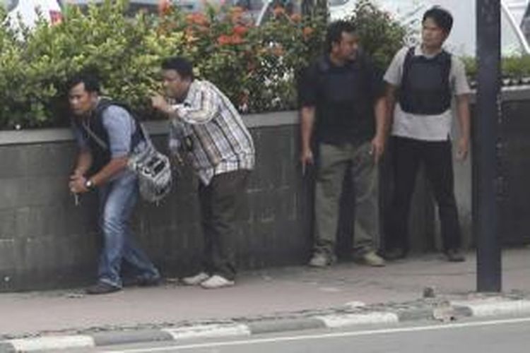 Polisi berpakaian sipil mengambil posisi saat mengejar terduga pelaku ledakan yang menghantam kawasan Jalan MH Thamrin, Jakarta Pusat, 14 Januari 2016. Serangkaian ledakan menewaskan sejumlah orang, terjadi baku tembak antara polisi dan beberapa orang yang diduga pelaku. 