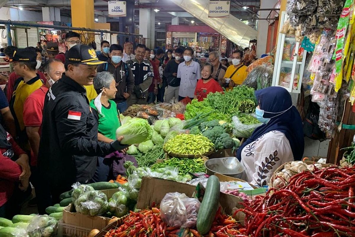 Wali Kota (Walkot) Madiun Maidi terlihat berkeliling ke pedagang penjual bahan pokok makanan untuk memantau langsung harga di Pasar Besar Kota Madiun, Jumat (23/9/2022). Tak hanya berkeliling, Walkot Maidi juga berkantor di Pasar Besar untuk menekan inflasi di Kota Madiun. 