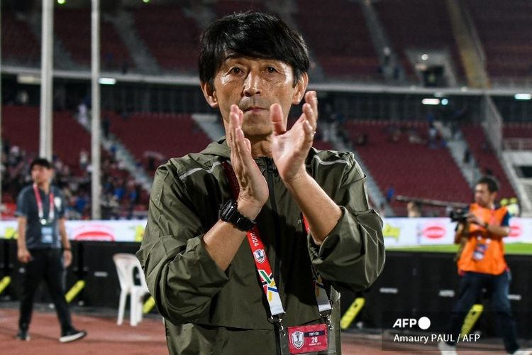 Masatada Ishii menyapa para pendukung di akhir pertandingan sepak bola grup ASEAN Championship 2024 antara Thailand vs Kamboja di Stadion Nasional Rajamangala di Bangkok pada 20 Desember 2024. (Foto oleh Amaury PAUL / AFP)