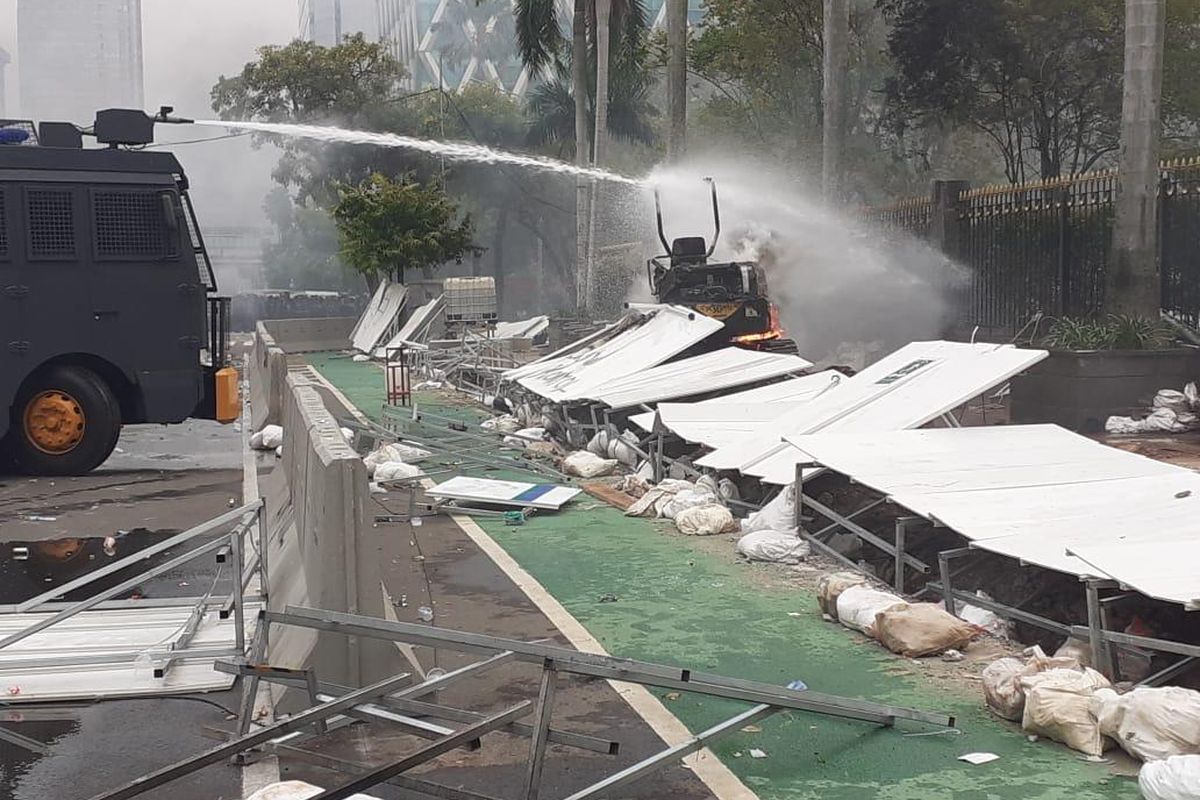 Mobil polisi saat memadamkan api eksavator proyek MRT Fase 2 yang dibakar oleh massa aksi, Kamis (8/10/2020)
