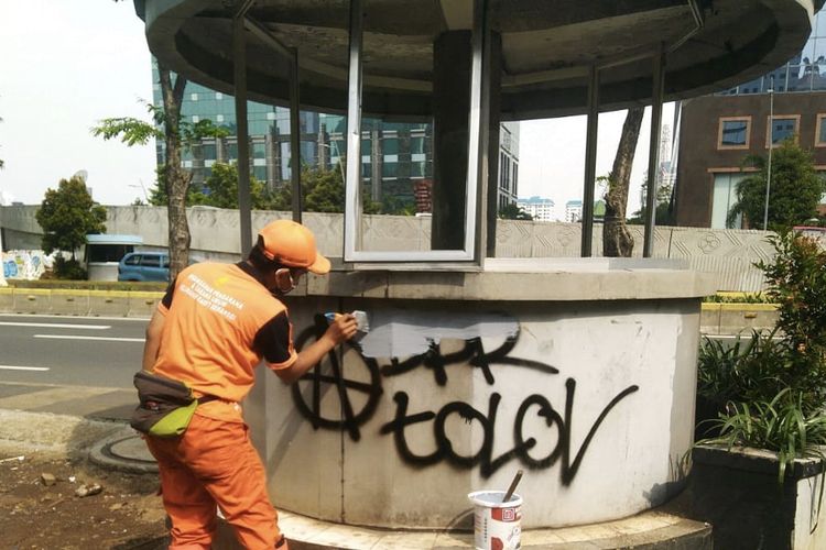 Petugas PPSU Setiabudi, Jakarta Selatan, mengecat coret-coretan dari aksi vandalime di sebuah Pos Polisi pada Jumat (9/10/2020) pagi. Aksi coret-coretan terjadi saat demo tolak UU Cipta Kerja kemarin.