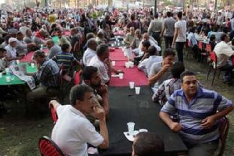 Ribuan umat Muslim dan Kristen Mesir berbuka puasa bersama di Lapangan Tahrir, Kairo pekan lalu sebagai simbol persatuan nasional negeri tersebut.
