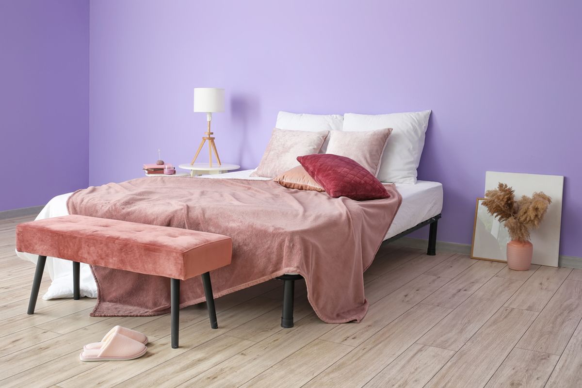 Ilustrasi kamar tidur dengan warna cat dinding ungu cerah. 