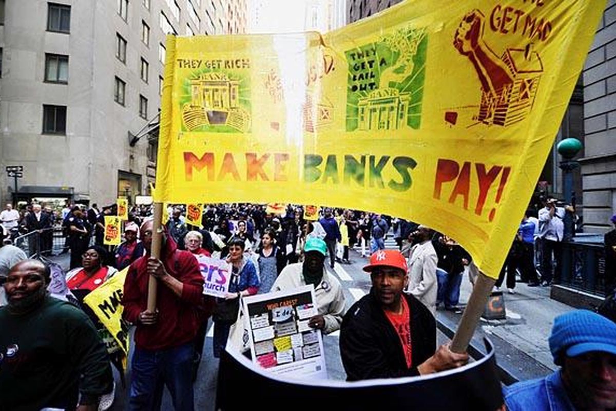 Para aktivis  dari Labor-Community Coalition  berdemonstrasi di Wall Street, New York, AS, Kamis (12/5). Wall Street adalah lokasi bagi salah satu bursa  saham utama AS, yang disinyalir penuh dengan para pelaku kejahatan kerah putih. Para aktivis berdemonstrasi karena banyaknya kasus penipuan di Wall Street.