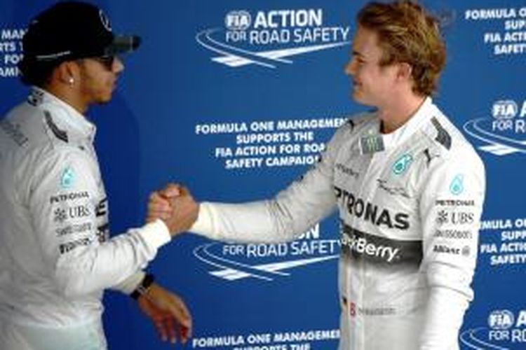 Pebalap Mercedes asal Jerman, Nico Rosberg (kanan), bersalaman dengan rekan satu timnya dari Inggris, Lewis Hamilton, setelah menyelesaikan sesi kualifikasi GP Brasil di Sirkuit Interlagos, Sabtu (8/11/2014).