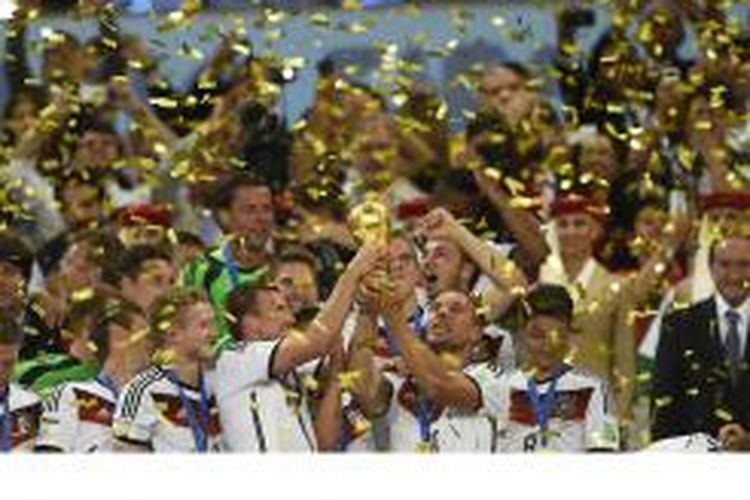 Para pemain Jerman menggenggam trofi Piala Dunia ketika merayakan kesuksesan mereka menjadi juara Piala Dunia 2014 setelah menang 1-0 atas Argentina di final, Minggu (13/7/2014) di Maracana Stadium di Rio de Janeiro, Brasil.