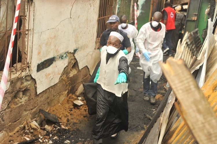 Petugas membawa kantong jenazah yang berisi jasad korban kebakaran sebuah sekolah Al Quran di Liberia, pada Rabu (18/9/2019).
