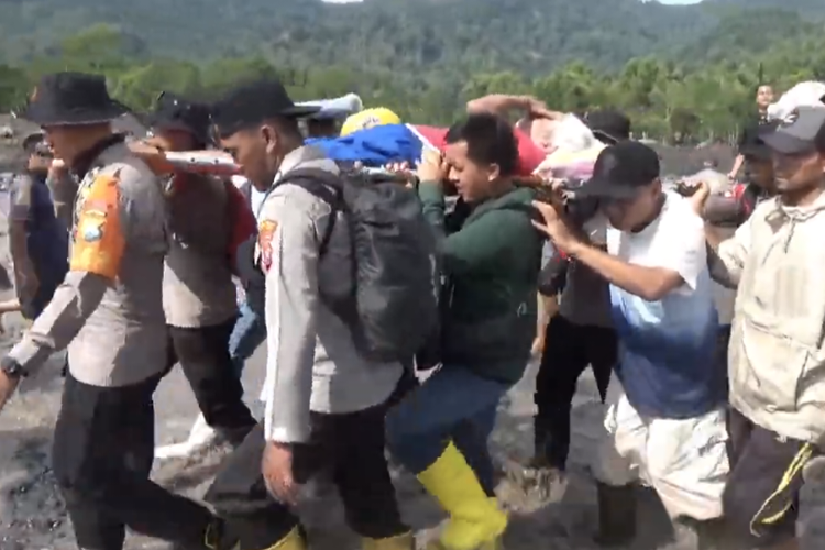 Petugas tandu lansia keluar dari Dusun Sumberlangsep untuk dibawa ke posko pengungsian